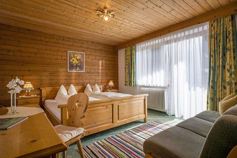 Doppelzimmer mit Couch und Balkon im Gästehaus Gmünderklause in Gerlos in Tirol